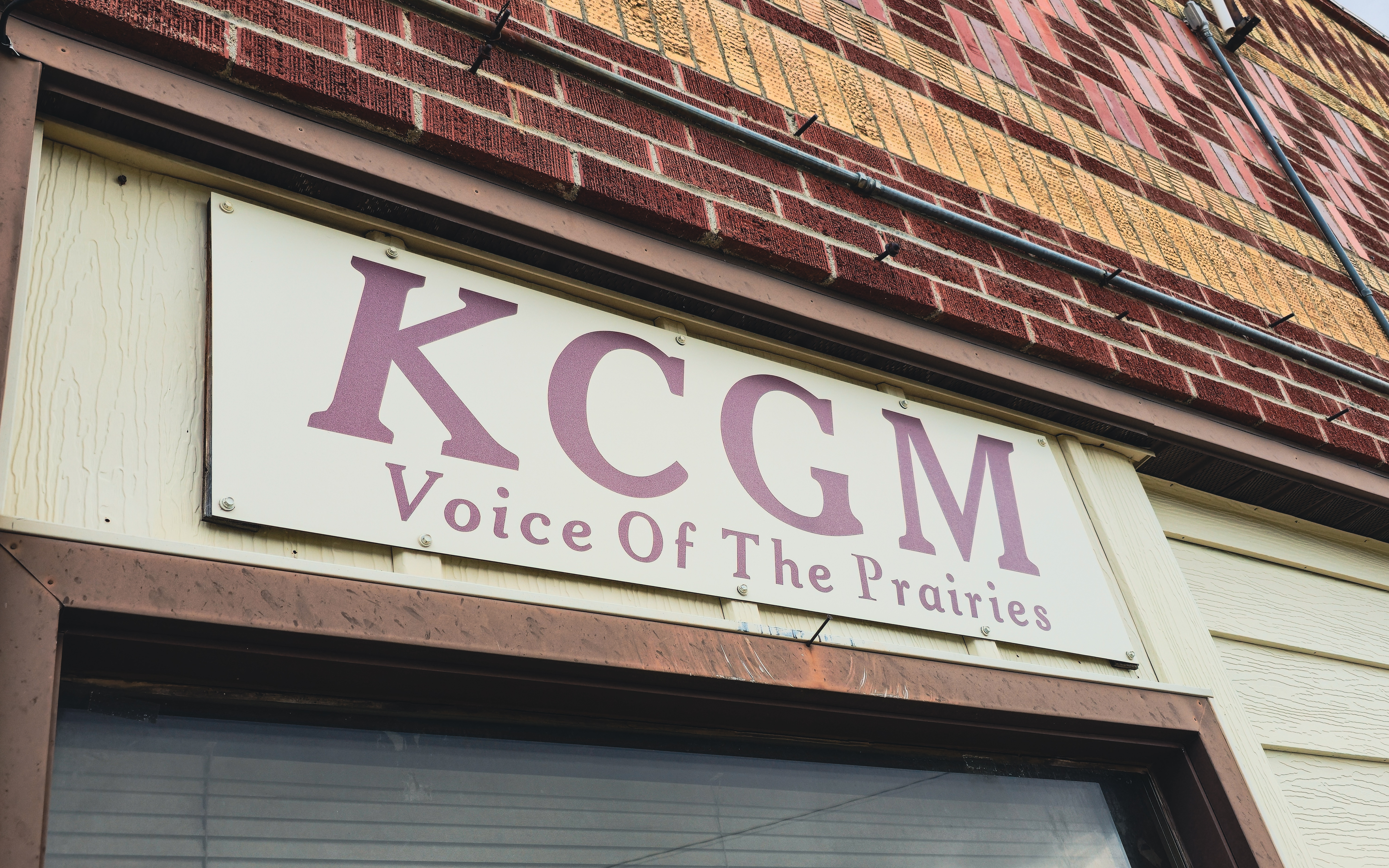 Sign for KCGM radio station displaying 'Voice Of The Prairies' at the studio entrance.